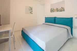 a bedroom with a blue bed and a table at La Casa Sul Corso in Santa Maria di Castellabate
