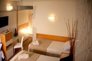 a hotel room with a bed and a table and a desk at Hotel Montecarlo - Hotel Vista Mare con Piscina & Area Fitness in Riccione
