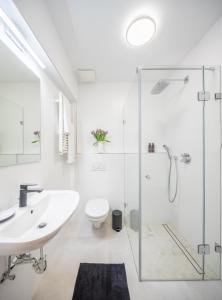 a white bathroom with a sink and a shower at Millennium Suite in Balatonfüred