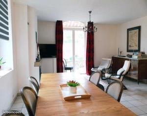 a dining room with a wooden table and chairs at L'ESCALE FAMILIALE, chambre d'hôtes in Saint-Sernin-du-Plain