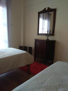 a bedroom with two beds and a mirror and a dresser at Sofia's House in Litochoro