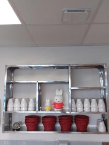 a shelf with bowls and two stuffed animals on it at Logis Hôtel Restaurant Lanex Amboise in Amboise