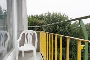 twee witte stoelen op een balkon met een raam bij ParkView Apartment 1 in Berlijn