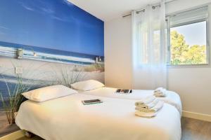 two beds in a room with a blue wall at Logis Les Vagues in Biscarrosse-Plage