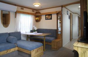 uma sala de estar com uma mesa e um sofá azul em Noclegi u Jagny em Zator