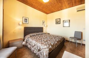 a bedroom with a bed and a chair in it at Hotel Aurelia in Tarquinia