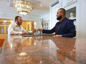 two men sitting at a table in a lobby at Hotel Kaiserhof in Lübeck