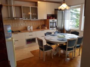 a kitchen with a table and chairs in a room at Apartman "Lara" in Ploče