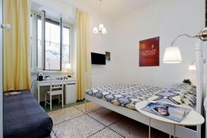 a bedroom with a bed and a desk and a window at Domus Ponte Milvio in Rome