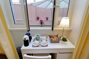einen kleinen Tisch mit einem Tee-Set und einem Fenster in der Unterkunft Domus Ponte Milvio in Rom