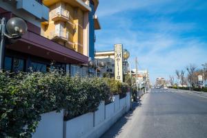 una strada di fronte a un edificio con piante di Hotel Melita a Rimini