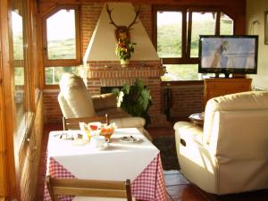 a living room with a table and a tv at Pensión Bella Vista in Cóbreces +18 photos