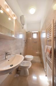 a white bathroom with a sink and a toilet at Hotel Aurelia in Tarquinia