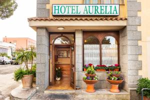 a hotel entrance with flower pots in front of it at Hotel Aurelia in Tarquinia