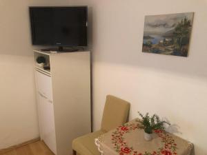 a dining room with a table and a tv on a wall at Bed & Breakfast Borka in Opatija