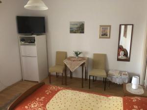 1 dormitorio con mesa, sillas y TV en Bed & Breakfast Borka, en Opatija