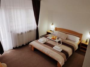 Un dormitorio con una cama grande y una mesa. en Guesthouse Kovačević, en Korenica