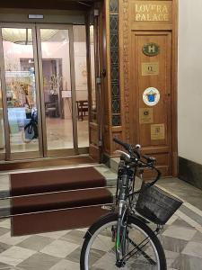 una bicicleta estacionada frente a un edificio en Hotel Palazzo Lovera, en Cuneo