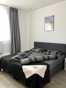 a bedroom with a black bed with pillows on it at Haus Estrella in Radolfzell am Bodensee