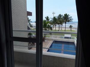 Blick auf den Pool aus dem Fenster in der Unterkunft Pousada e Restaurante Cantinho Oriental in Bertioga