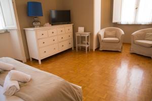 une chambre avec deux lits et une télévision et une chaise dans l'établissement Amalia Vatican House, à Rome