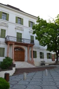 a large white building with a wooden door at Millennium Suite in Balatonfüred