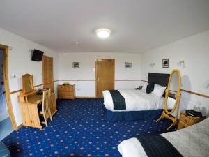a hotel room with two beds and a mirror at Orkneylodge in Orphir