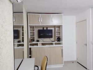 a living room with a tv and a desk and chairs at Eilat. אילת Pousada Bacacheri in Curitiba