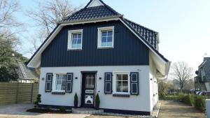 een zwart-wit huis met een zwart dak bij Haus Sommerliebe in Prerow