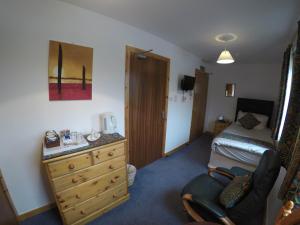 a room with a bedroom with a bed and a dresser at Orkneylodge in Orphir