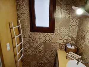 a bathroom with a sink and a window on a wall at Luxury studio in the centre of Palaikastro in Palekastron