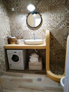 a bathroom with a sink and a washing machine at Luxury studio in the centre of Palaikastro in Palekastron