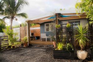 Cette petite maison dispose d'une terrasse ornée de plantes. dans l'établissement Chez Les Filles - Bungalodge, à Petite Île