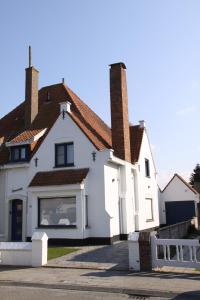 Cette maison blanche dispose d'une grande fenêtre. dans l'établissement Villa Zonneweelde, au Coq