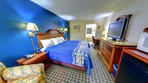 a hotel room with a bed and a flat screen tv at Dahlonega Mountain Inn in Dahlonega