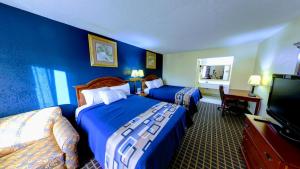 a hotel room with two beds and a flat screen tv at Dahlonega Mountain Inn in Dahlonega