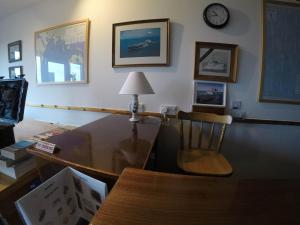 a living room with a table and a chair and a clock at Orkneylodge in Orphir +34 photos