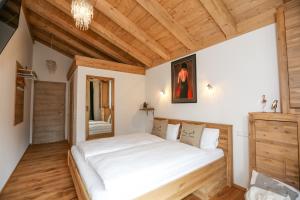 ein Schlafzimmer mit einem großen Bett in einem Zimmer mit Holzdecken in der Unterkunft Landhaus Wiesner - Gästezimmer - Bad - Bett - Kleine Kaffee - Tee-Theke mit Kühlschrank - Parkplatz in Rottach-Egern
