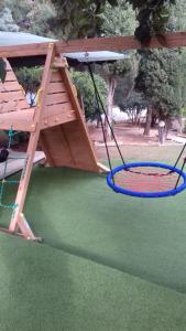 a playground with a swing and two tennis rackets at Villa Verde Apartments and Rooms in Premantura