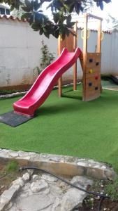 a small playground with a slide in a yard at Villa Verde Apartments and Rooms in Premantura