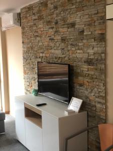 salon z kamienną ścianą i telewizorem w obiekcie Komfortowe Apartamenty w Okunince