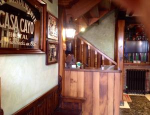 a bar in a pub with wooden walls and a staircase at Casa Cayo in Potes