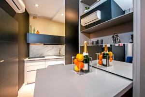 una cucina con un bancone con bottiglie e arance sopra di Deluxe Studio G 12 a Rovigno (Rovinj) Altre 8 foto