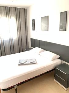 a bedroom with a large white bed and a window at Apartamento Calafell playa in Calafell