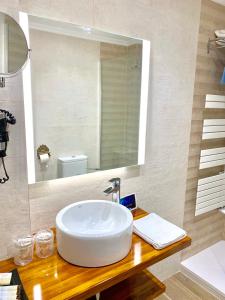 a bathroom with a white sink and a mirror at Hotel Tres Coronas de Silos in Santo Domingo de Silos