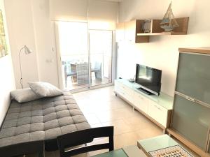 sala de estar con sofá y TV de pantalla plana en Apartamento Calafell playa, en Calafell