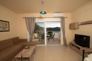 a living room with a couch and a television at Seaside Apartment-George in Kaloi Limenes