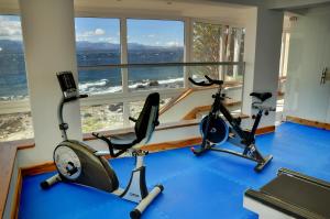 a gym with two exercise bikes in front of a window at Hotel Huemul in San Carlos de Bariloche
