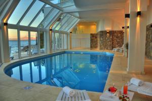 a swimming pool in a house with a glass ceiling at Hotel Huemul in San Carlos de Bariloche