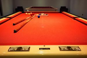 a red pool table with two cue sticks and balls at Grand Hotel Presolana in Castione della Presolana